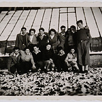 Groepsfoto in de sneeuw van leden van de Joodse jeugdfarm aan de Ridder van Catsweg vóór een kas, ca. 1942.